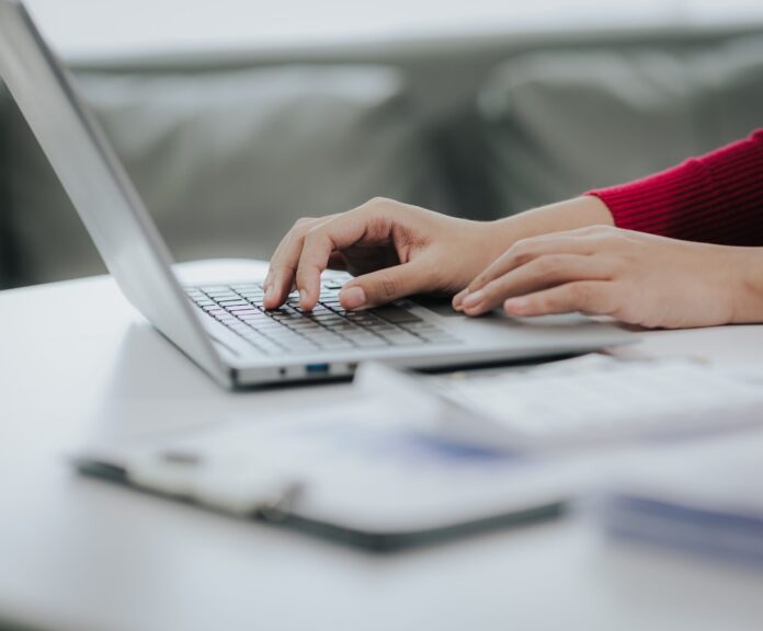 Close-up,Of,Female,Accountant,Using,Calculator,And,Laptop,Computer,And